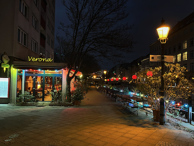 Osvětlená restaurace a ulice v Berlíně.