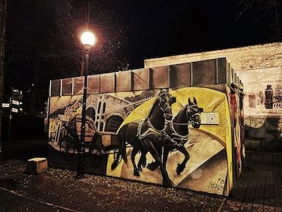 Svítidlo veřejného osvětlení osvětlující grafitovou malbu.